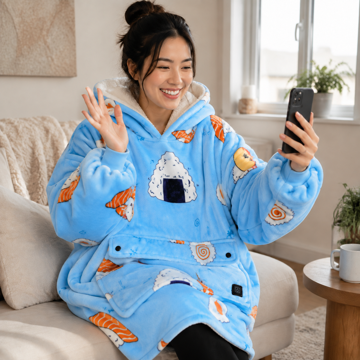 Woman in BardiHeat Heated Fleece waving while on a video call, featuring colorful sushi patterns.