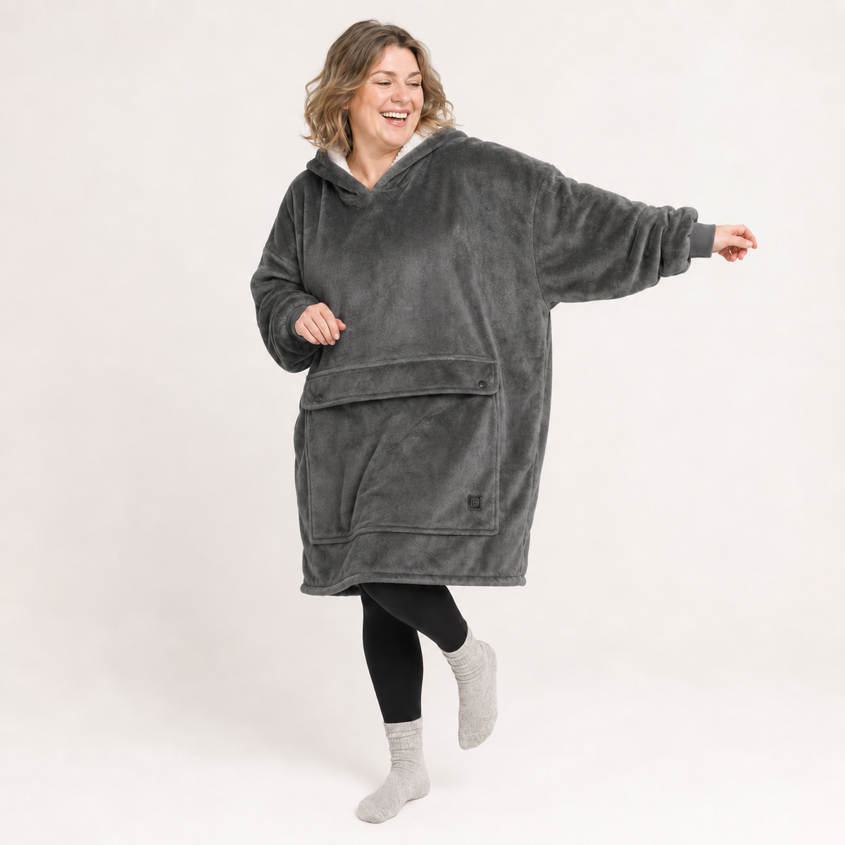 Grey BardiHeat heated fleece worn in a playful studio pose with two pocket-closing buttons
