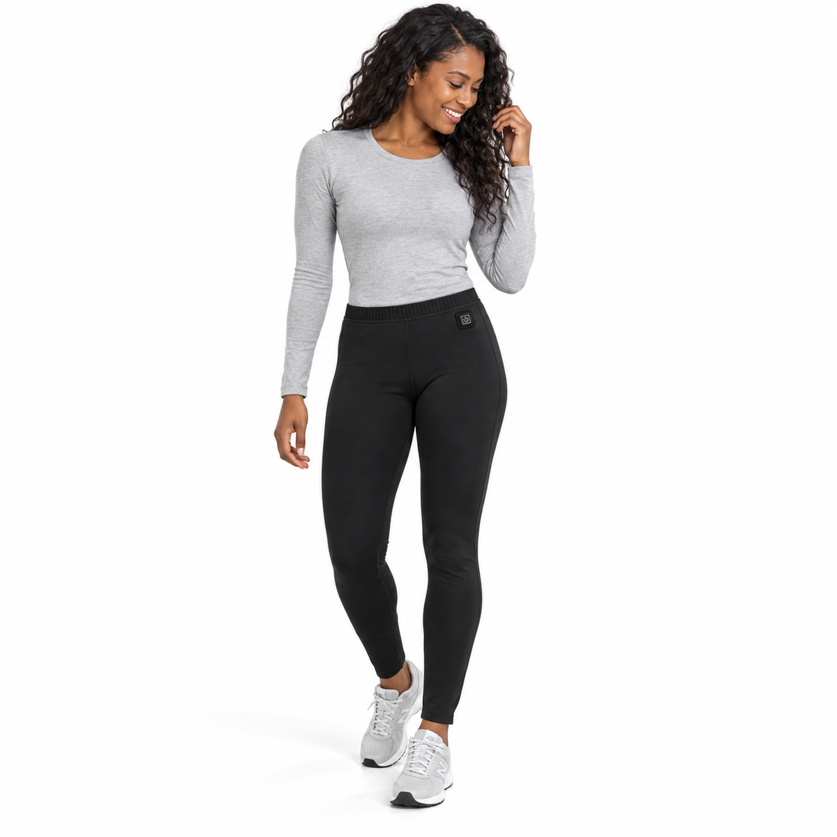 Model wearing women's black Heated Thermal Trousers in a white studio