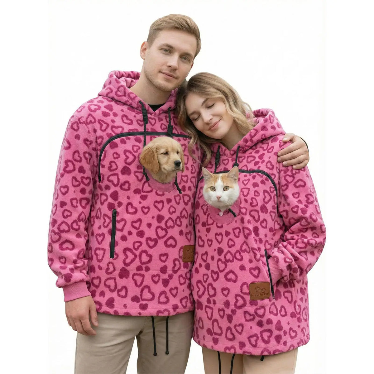 Two people wearing Rose Red Pet Pouch Fleeces with a small dog and cat