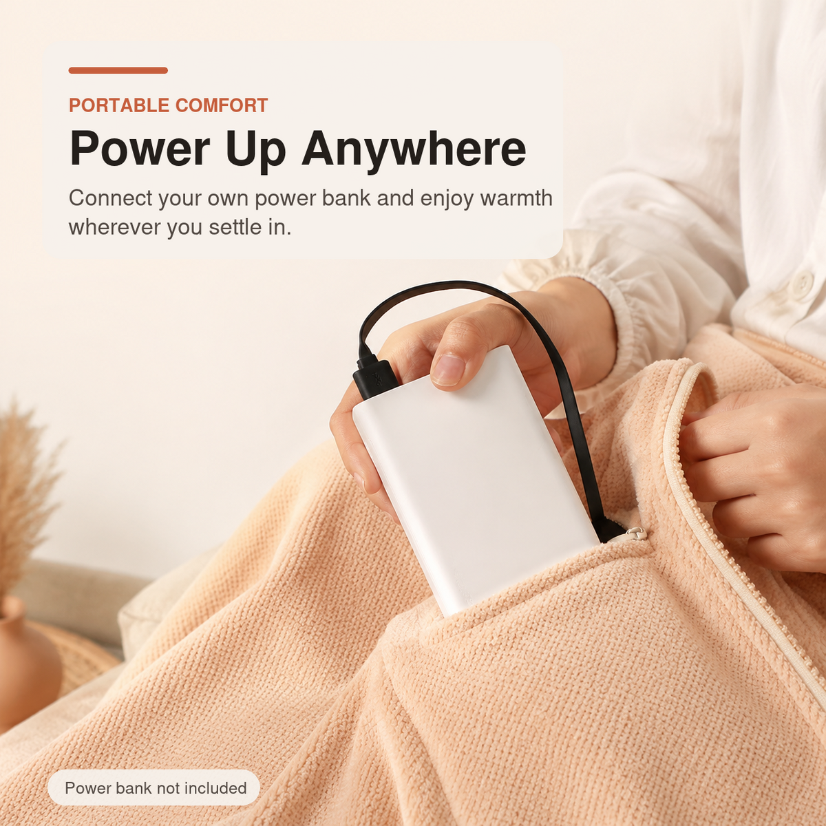 Wearable Heated Blanket connecting to a USB power bank stored in its zipped pocket